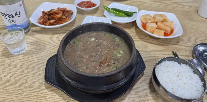 Momguk at Ujin Haejangguk served with side dishes and a bottle of Hallasan soju
