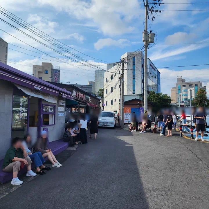 Customers waiting in line in the alley outside Ujin Haejangguk in Jeju