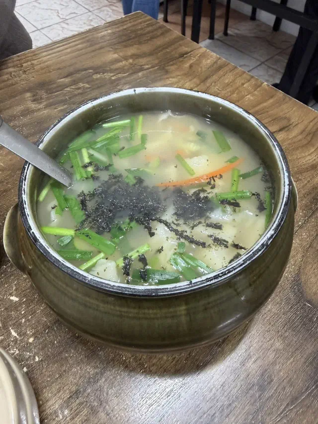 Earthenware pot of Samcheongdong Sujebi for two, filled with hand-torn noodles in clear broth