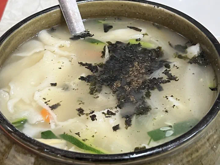 Close-up of the paper-thin sujebi dough and clear anchovy-clam broth at Samcheongdong Sujebi