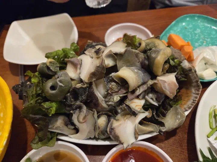 Plate of chamsora, steamed sea snail sliced with its innards, the signature dish at Seochon Gyedanjip