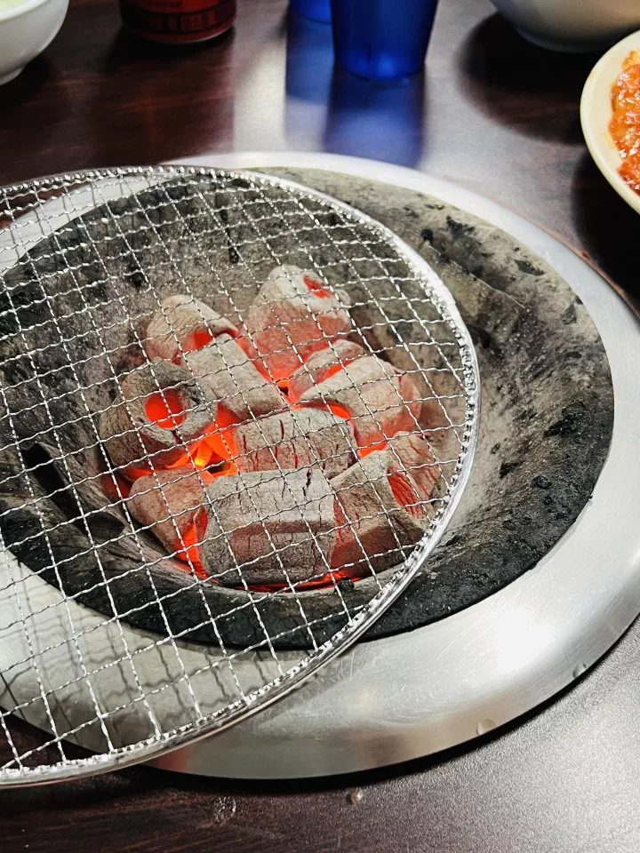 충무로쭈꾸미불고기에서 석쇠를 한쪽으로 비스듬히 밀어 놓은 숯불 화로
