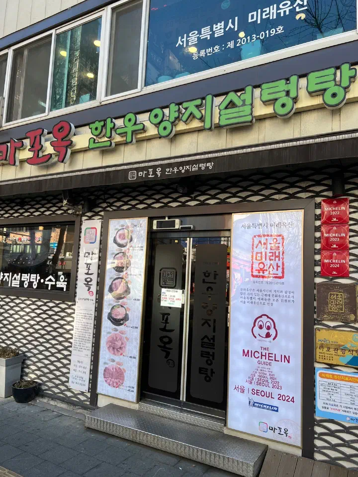 마포옥 정문 입구에 붙은 미쉐린 가이드와 서울 미래유산 표지