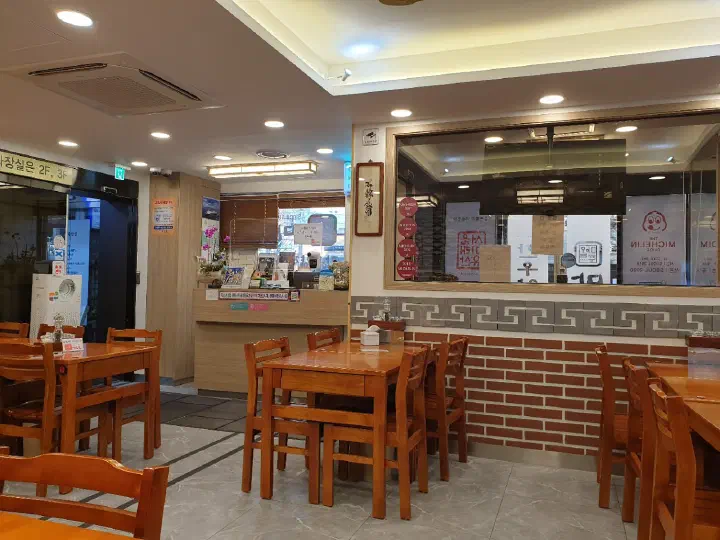 마포옥 1층 홀에 놓인 원목 테이블과 좌석