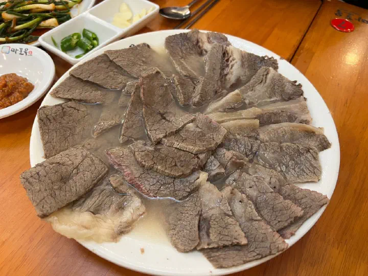접시 가득 담긴 마포옥 한우 모듬수육과 청양고추, 마늘
