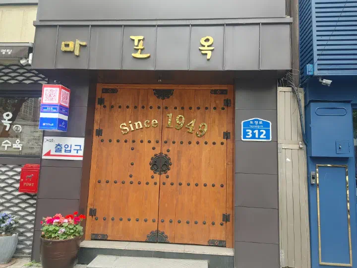 Since 1949가 새겨진 마포옥 나무 대문과 토정로 312 주소 표지