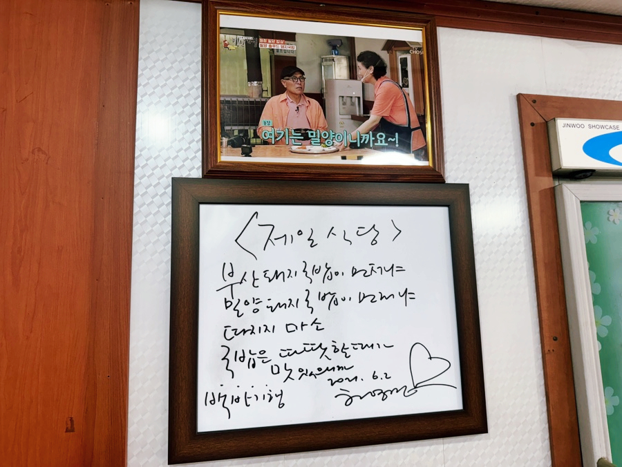 A still from Baekban Travels mounted above the autograph frame