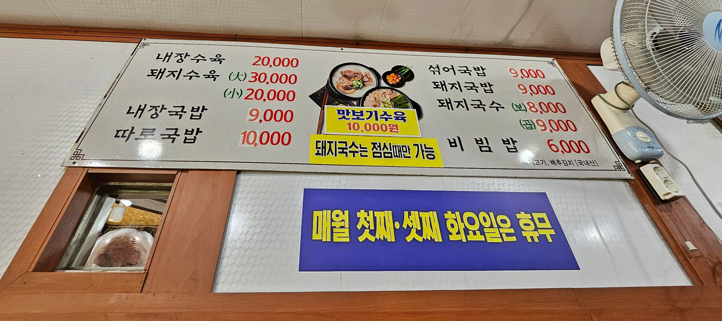 Menu board listing soups, noodles, and boiled pork