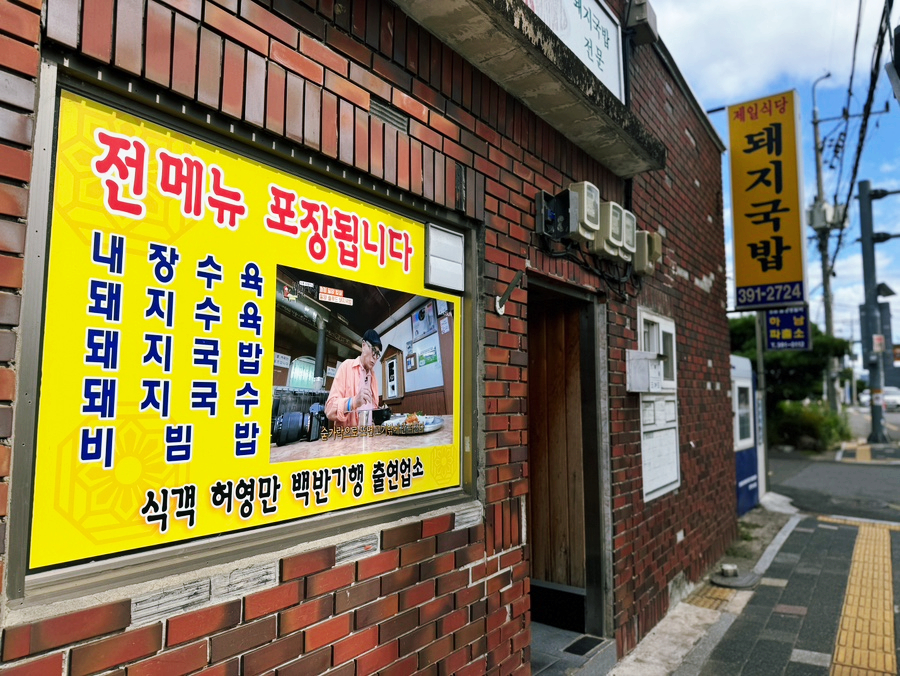 A yellow signboard listing all dishes available for takeout