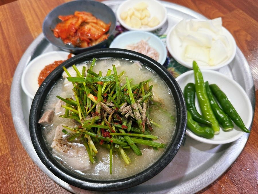 Pork soup, rice, and side dishes laid out across the table