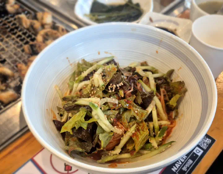 Spicy cold noodles (bibim-guksu) topped with cucumber and lettuce in a sweet-tangy sauce
