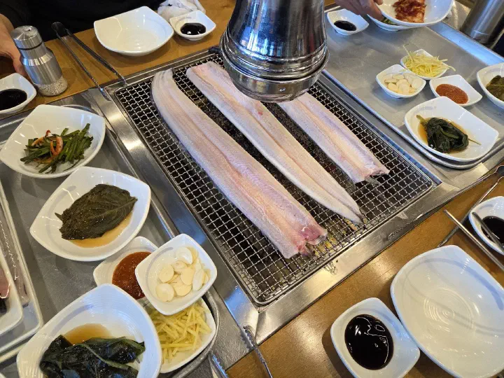 달군 석쇠에 통째로 올려 굽기 시작한 민물장어
