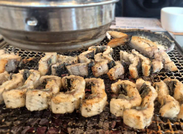 Close-up of golden salt-grilled eel, crisp outside and plump inside