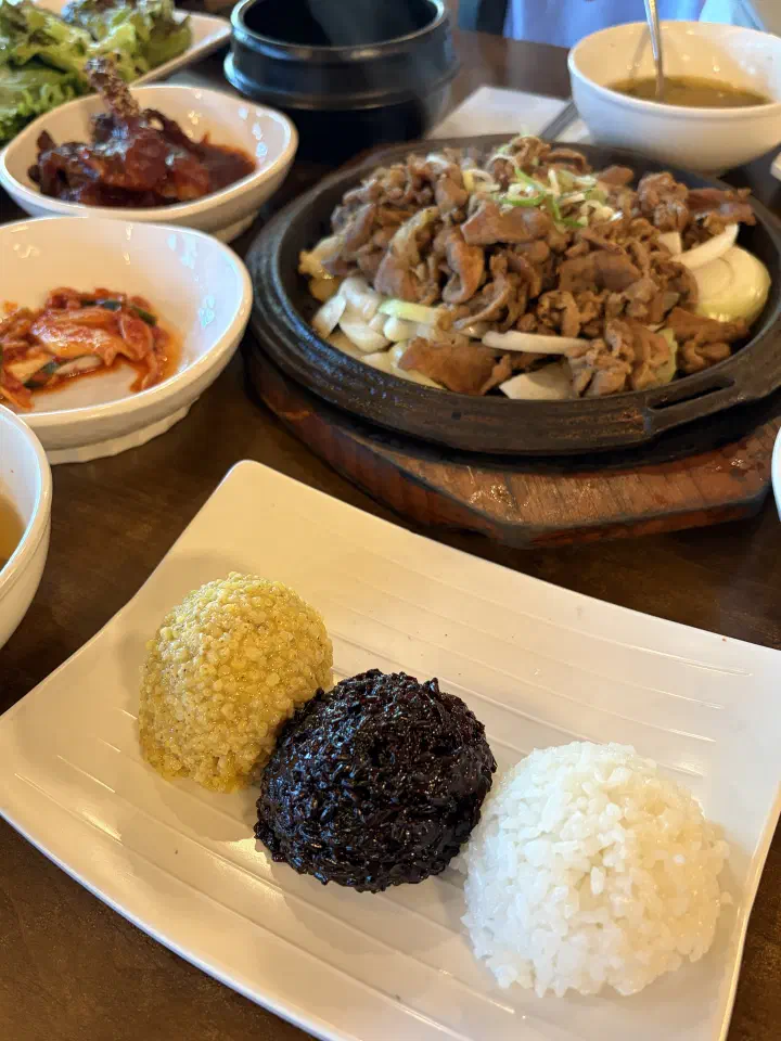 Samsaekbap at Mokhyangwon, three scoops of white rice, black rice, and millet served beside the grilled pork plate