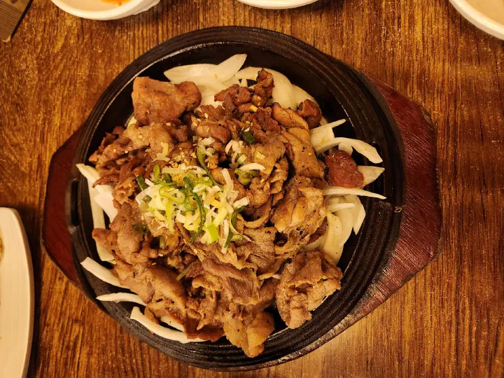 Overhead view of one 200 gram portion of Mokhyangwon seoksoe bulgogi piled on sliced onions