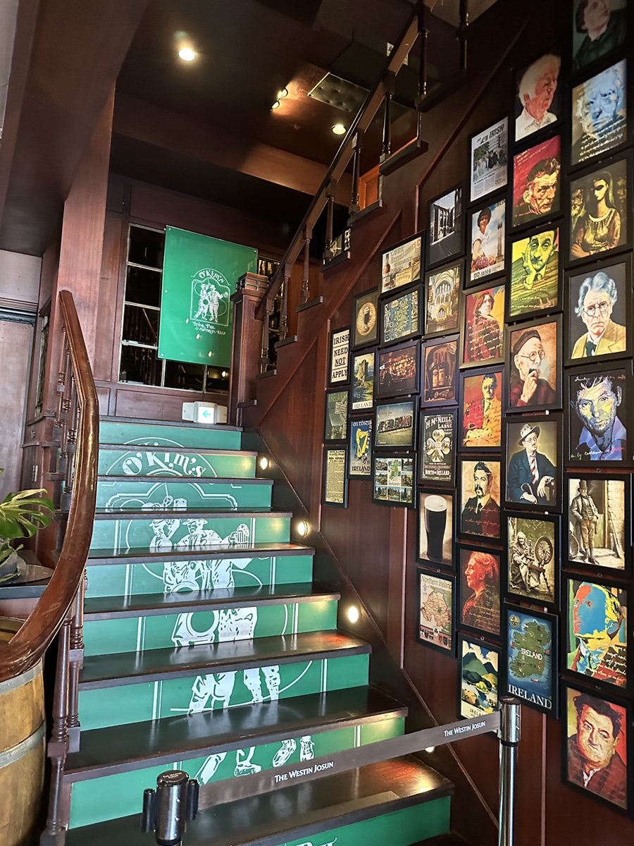 Green staircase with Irish portraits at O’Kim’s