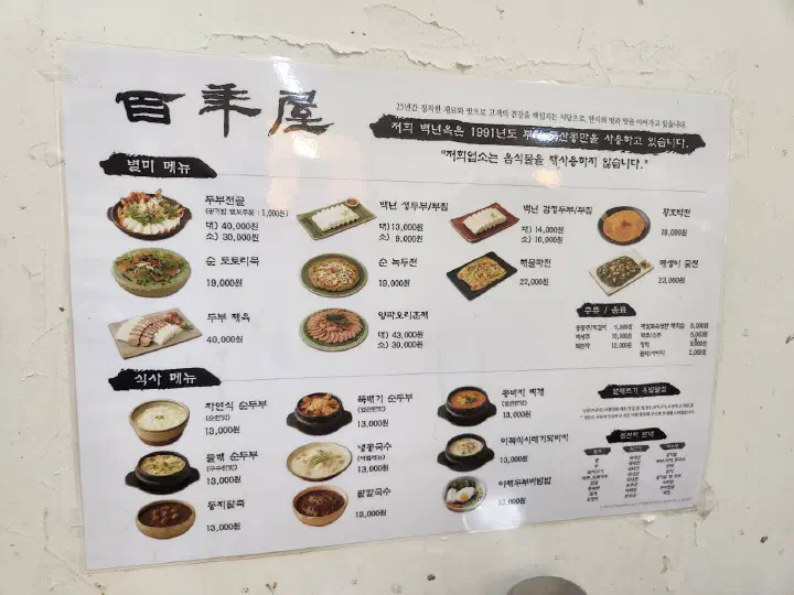 백년옥 벽에 붙은 메뉴판, 두부전골과 순두부 등 메뉴별 가격과 국내산 원산지 표기