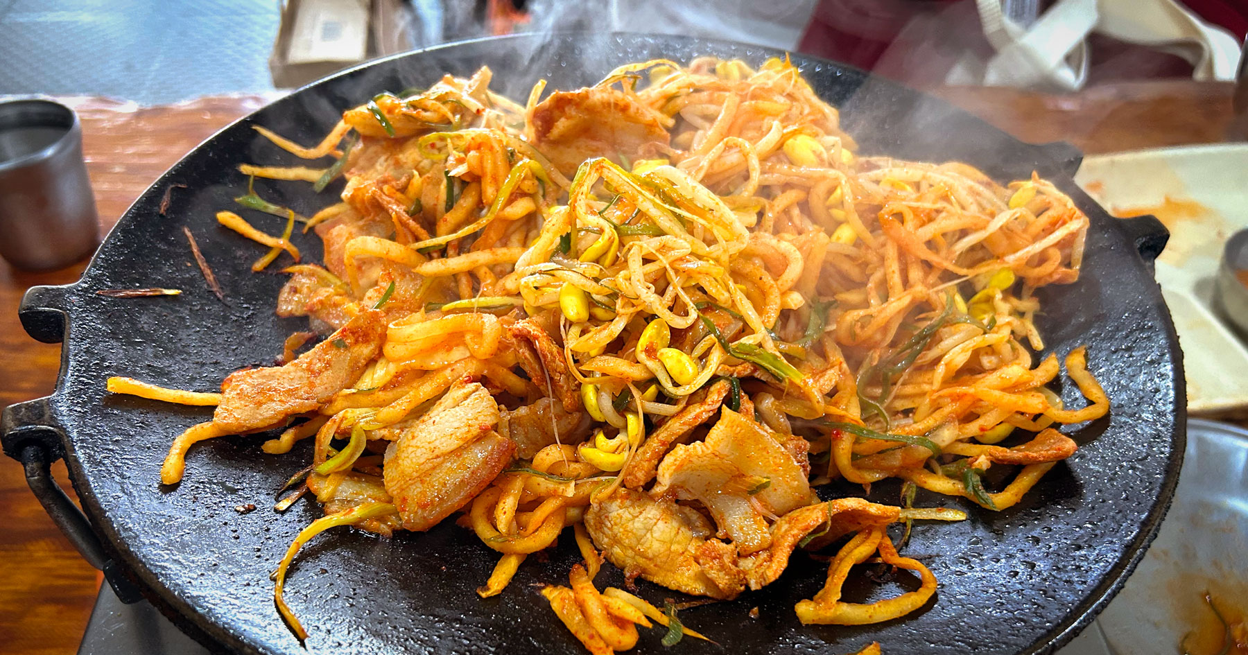 Jeju-style pork duruchigi sizzling on a tabletop grill at Yong-ee Sikdang, Seogwipo