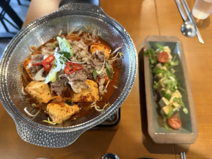 Chadol dubu jorim and a tofu salad plate arriving at the table