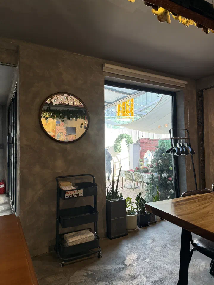 Window seat inside the converted house looking out to the small yard with outdoor tables