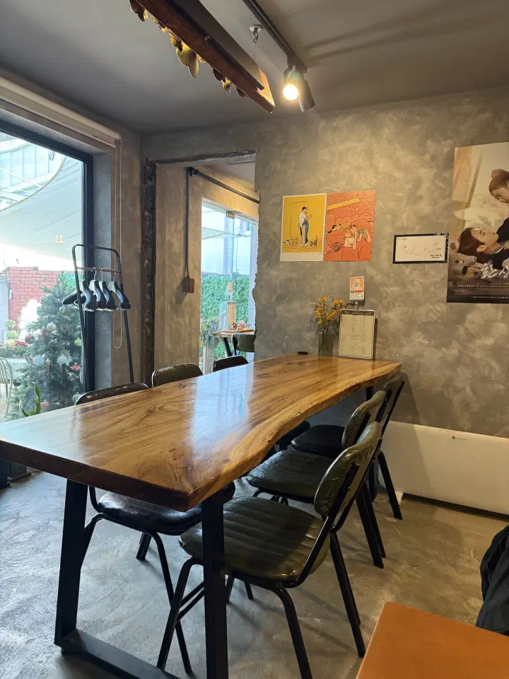 Interior of Food Gallery Bean with a large solid wood table and framed art on the wall