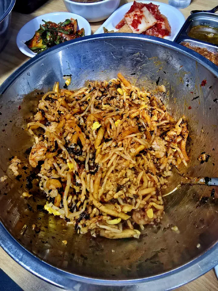 Bibimbap tossed with sauce in a wide stainless steel basin at Seoul Matzip
