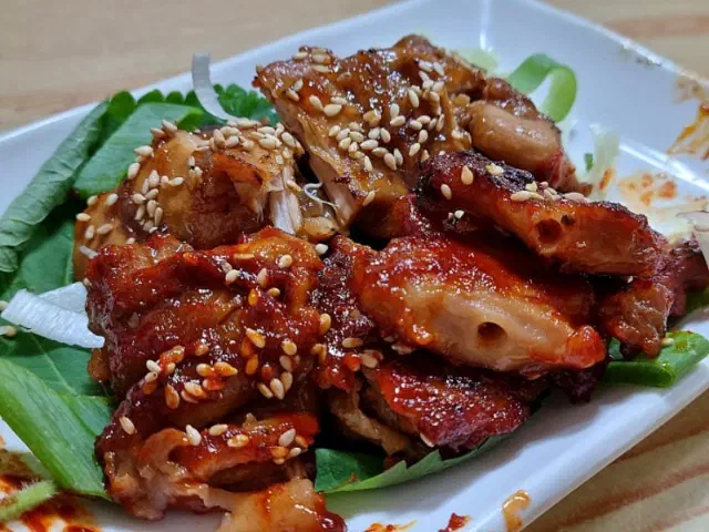 Charcoal-grilled chicken skewers in teriyaki and spicy glaze on a white plate