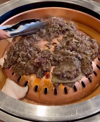 Hanwoo bulgogi cooking on the domed copper grill at Woo Lae Oak