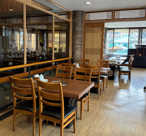 Interior dining hall of Woo Lae Oak in Euljiro with wood-toned tables and chairs