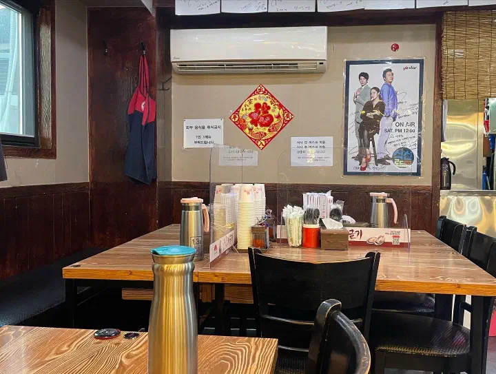 Interior of Yeonghwaru with tables, a TV-show poster and autographs on the wall