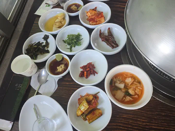 88생선구이 반찬 한 상, 배추김치와 미역줄기·꽈리고추무침·오징어젓갈과 마늘 고추냉이 간장 종지