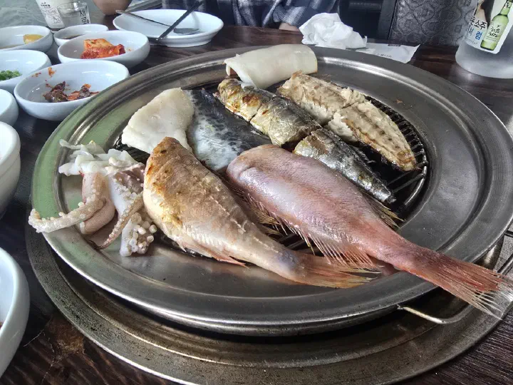 88생선구이 숯불 화로에 나란히 올라간 가자미와 꽁치, 고등어, 오징어