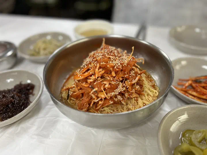 속초 아바이회국수의 가자미 회무침이 수북하게 올라간 회국수 한 그릇과 밑반찬