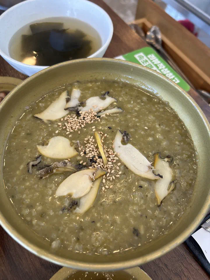 Warm abalone porridge at Chungchosoo Mulhoe Sokcho, sliced abalone and sesame seeds on top, a mild option for kids