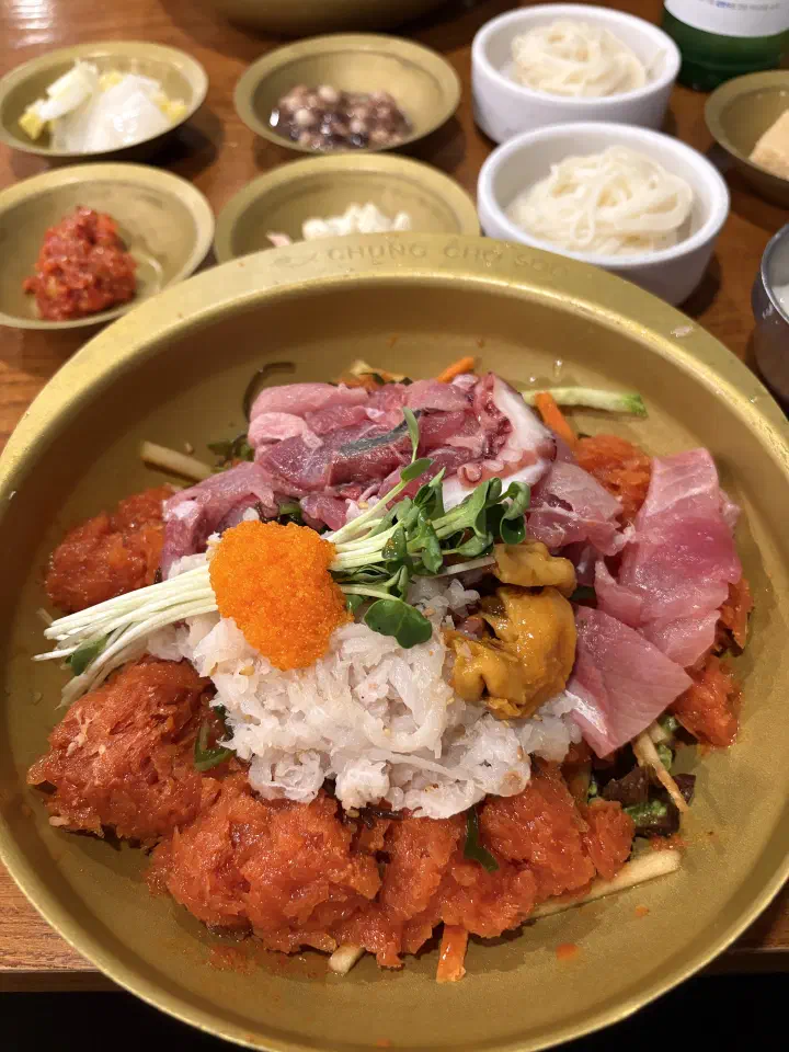 Full mulhoe table setting at Chungchosoo Mulhoe Sokcho, with rice, thin somyeon noodles and Korean side dishes