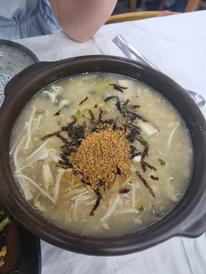 A bowl of Gamnamujip gamja ongsimi topped with perilla powder and seaweed flakes