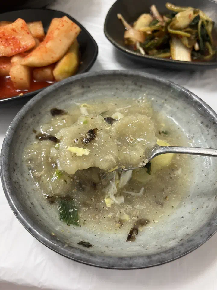 Grated potato dumplings lifted on a spoon, showing their soft gnocchi-like texture