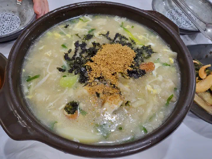 A spoonful of toasted perilla seed powder stirred into gamja ongsimi broth