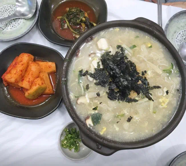 Two portions of gamja ongsimi in one large pot with kkakdugi, yeolmu kimchi and minced chili