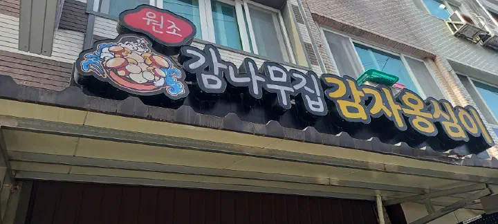Storefront sign of Wonjo Gamnamujip Gamja Ongsimi in a Sokcho Jungang Market alley