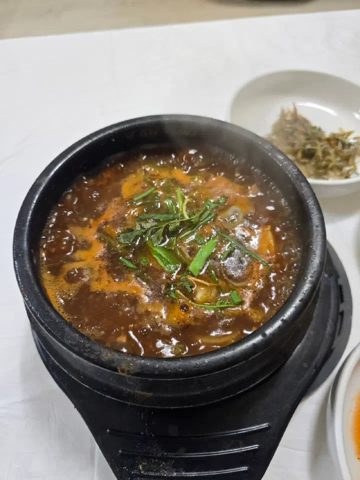 Dark, earthy doenjang-jjigae made with house-fermented soybean paste, served in a stone pot