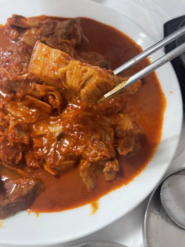 A fatty piece of braised pork lifted from the duruchigi with chopsticks