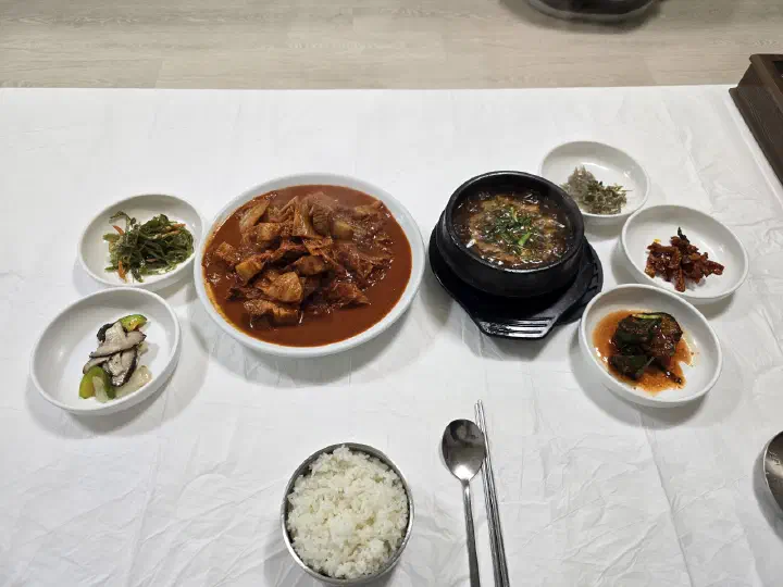 Full table setting of duruchigi, stew, rice and side dishes on a low floor table