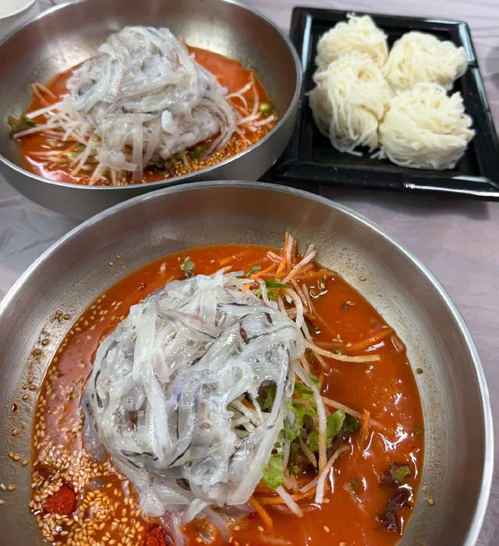 속초 완도회식당 산오징어물회 두 그릇과 소면 한 접시가 함께 차려진 모습