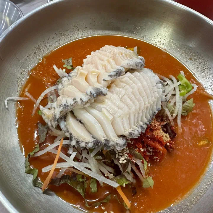 두툼하게 썰린 특 사이즈 산오징어가 올라간 물회 클로즈업