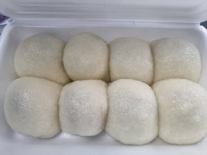 Close-up of eight chapssal mochi in a Yukgu Bangatgan box, with coarsely milled rice grains visible in the skin