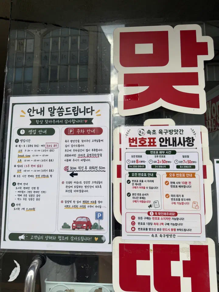 Notice signs on the door of Yukgu Bangatgan in Sokcho listing business hours and numbered ticket handout times