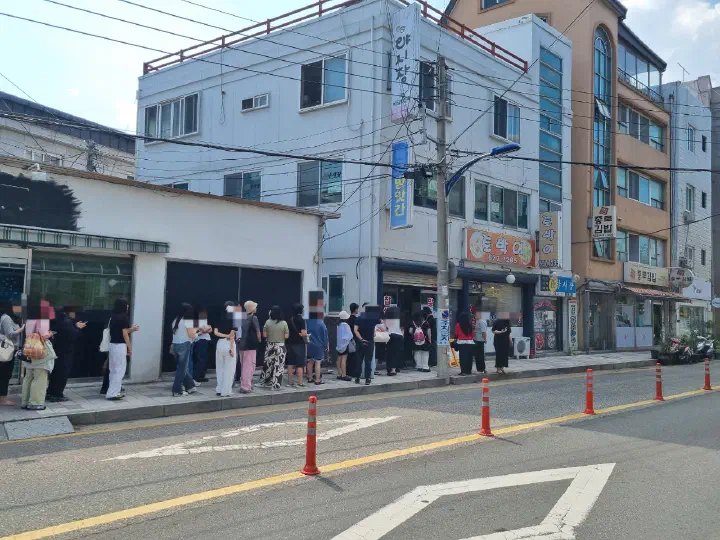 Customers lined up on the shadeless sidewalk outside Yukgu Bangatgan during the morning round in Sokcho