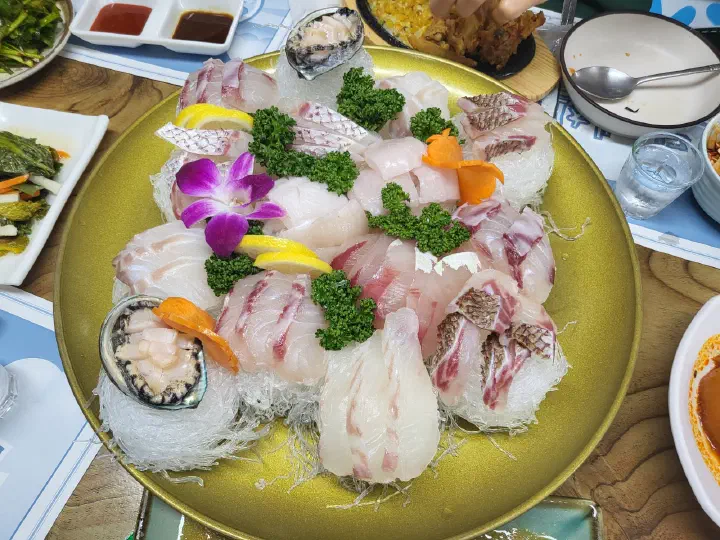 바다예찬 숙성모듬회 단품, 금색 접시에 담긴 흰살생선회와 전복