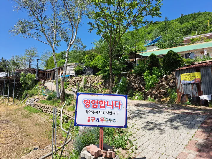 구와우순두부식당 입구에 세워진 영업합니다 안내 팻말과 마당 주차 공간